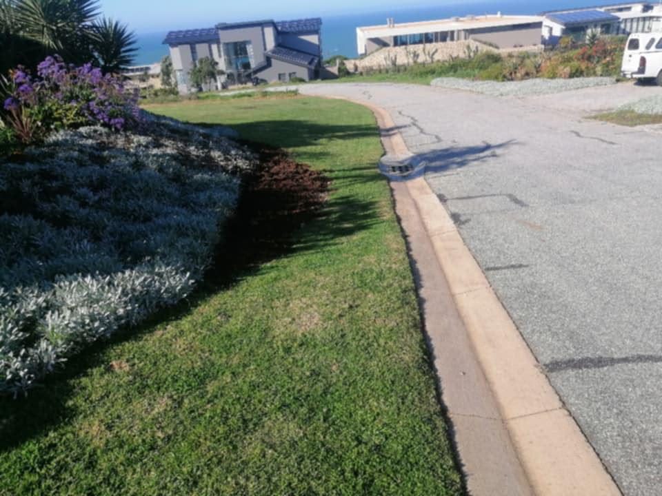 Neatly edged lawn along a kerb with flowering beds