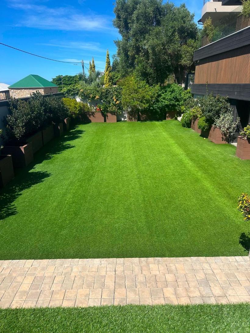 Deep green lawn mown into stripes between raised planter boxes